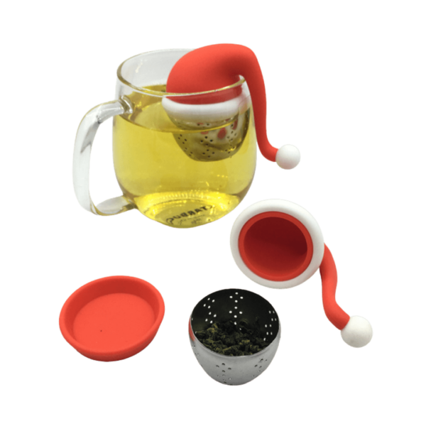 Julehat te-infuser i en kop varm te sammen med en åben te-infuser, som er fyldt med te