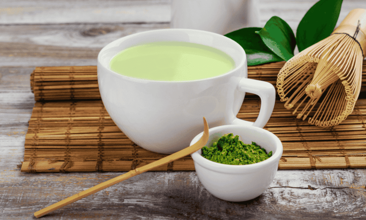 Matcha Te pulver til at lave en kop Matcha te, som står på et bord