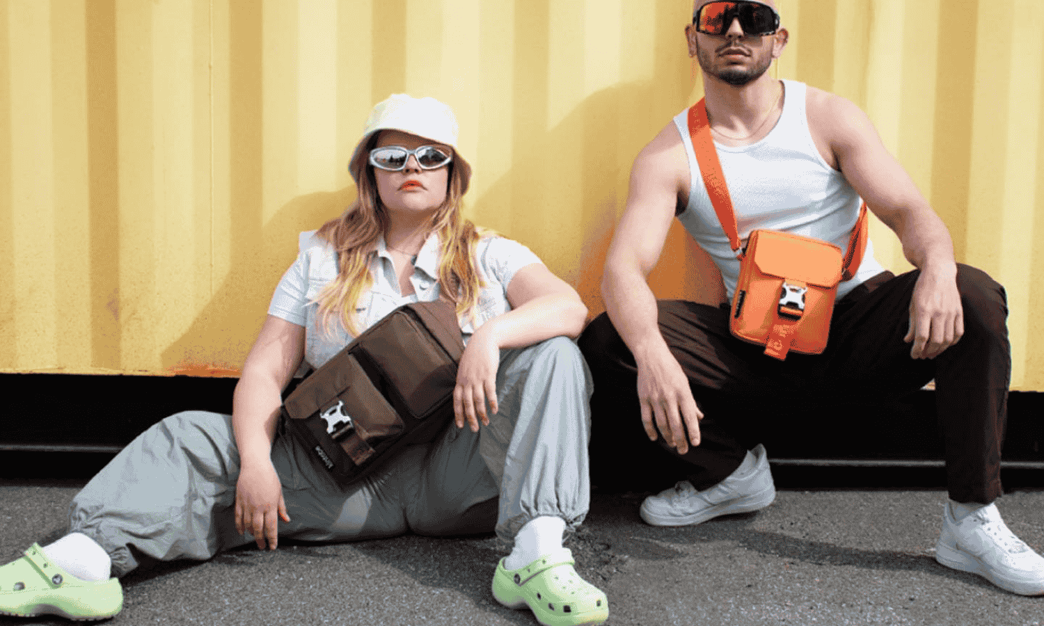 2 personer som sidder op af en gul væg med en Miles og Luca taske fra Kintobe