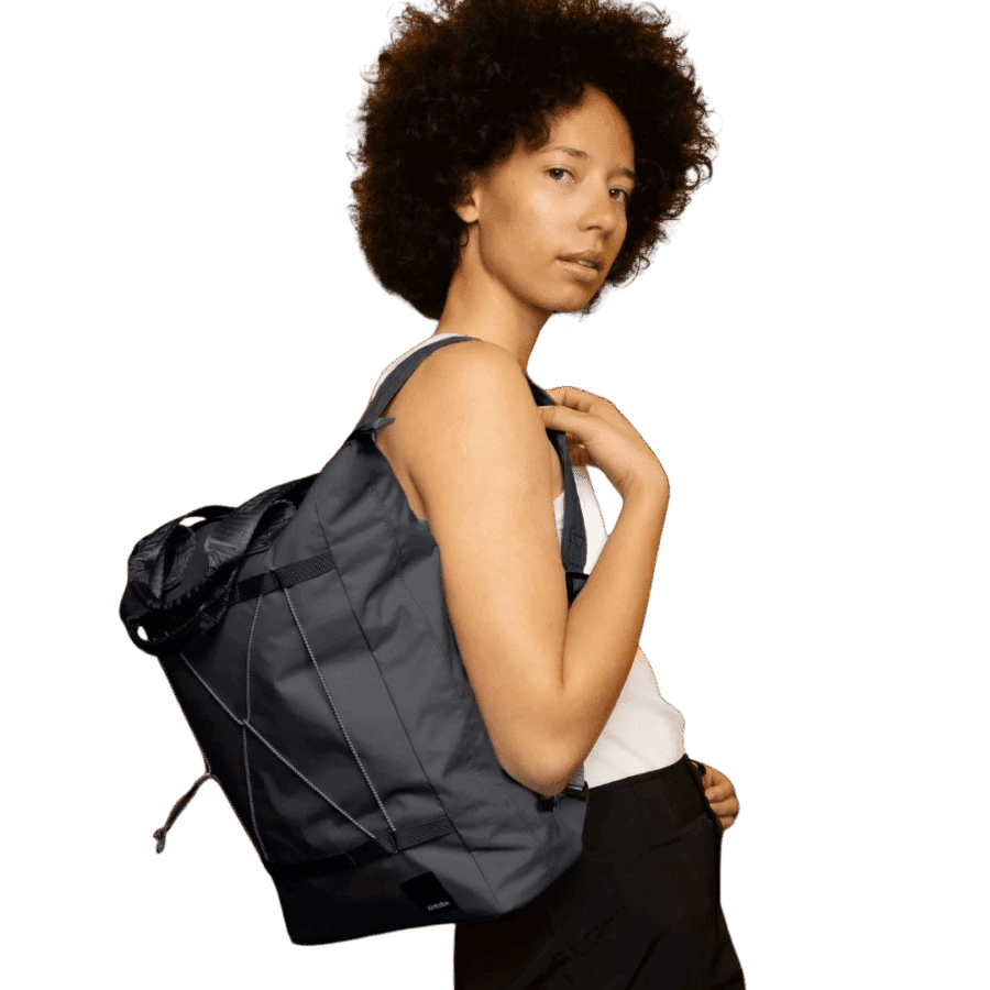 Kvinde der står med en Kintobe TATE Bag i Jet Black