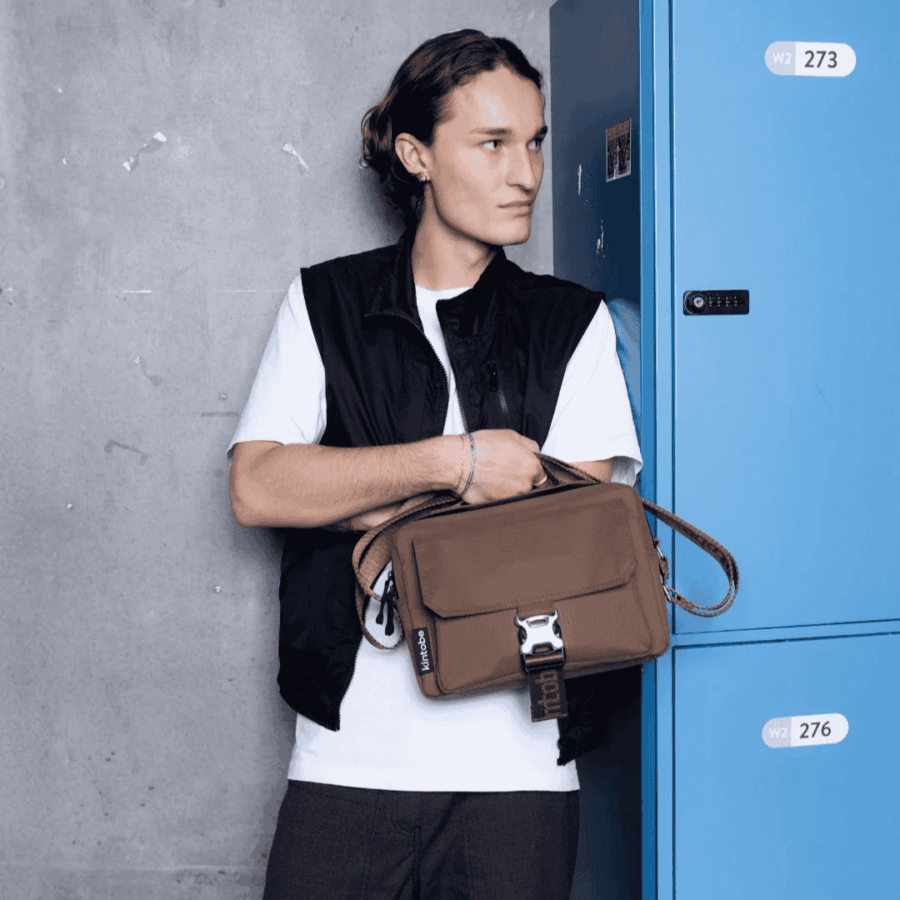Mand der står med en NOAH Cross-Body bag fra Kintobe i Earth Brown