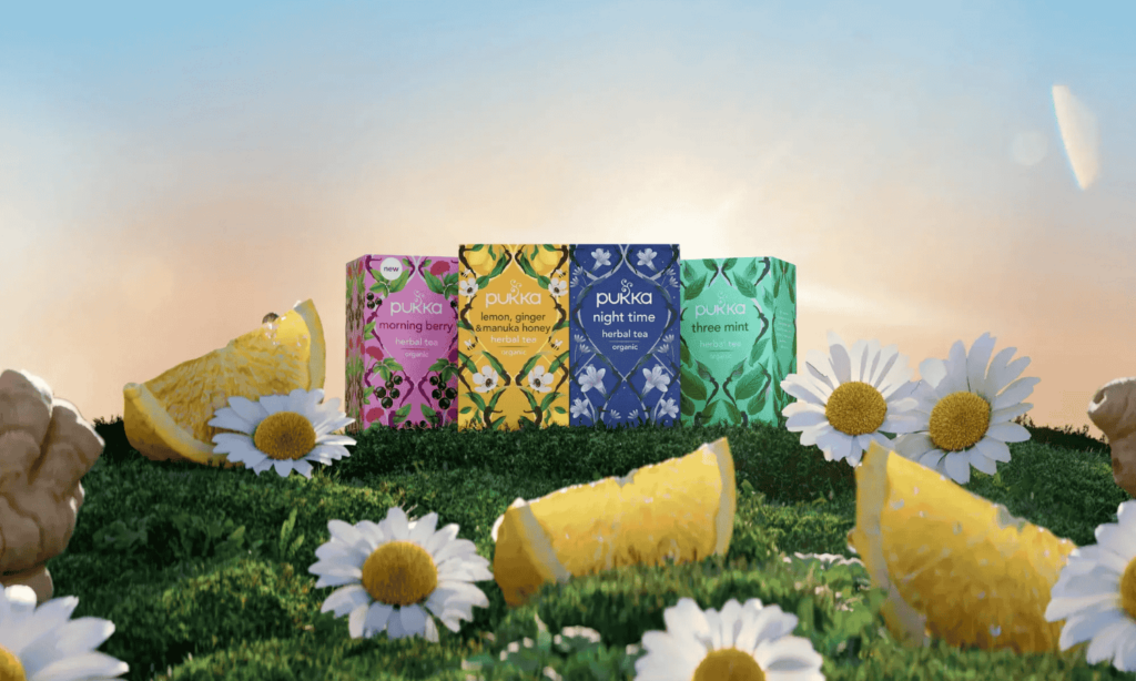 Pukka te som står på en bjergtop midt på en blomstereng