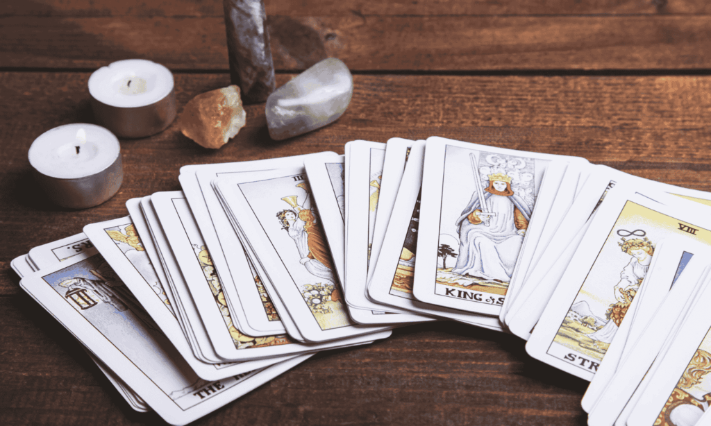 Englekort der ligger foldet ud i en vifte på et træbord med krystaller og lys