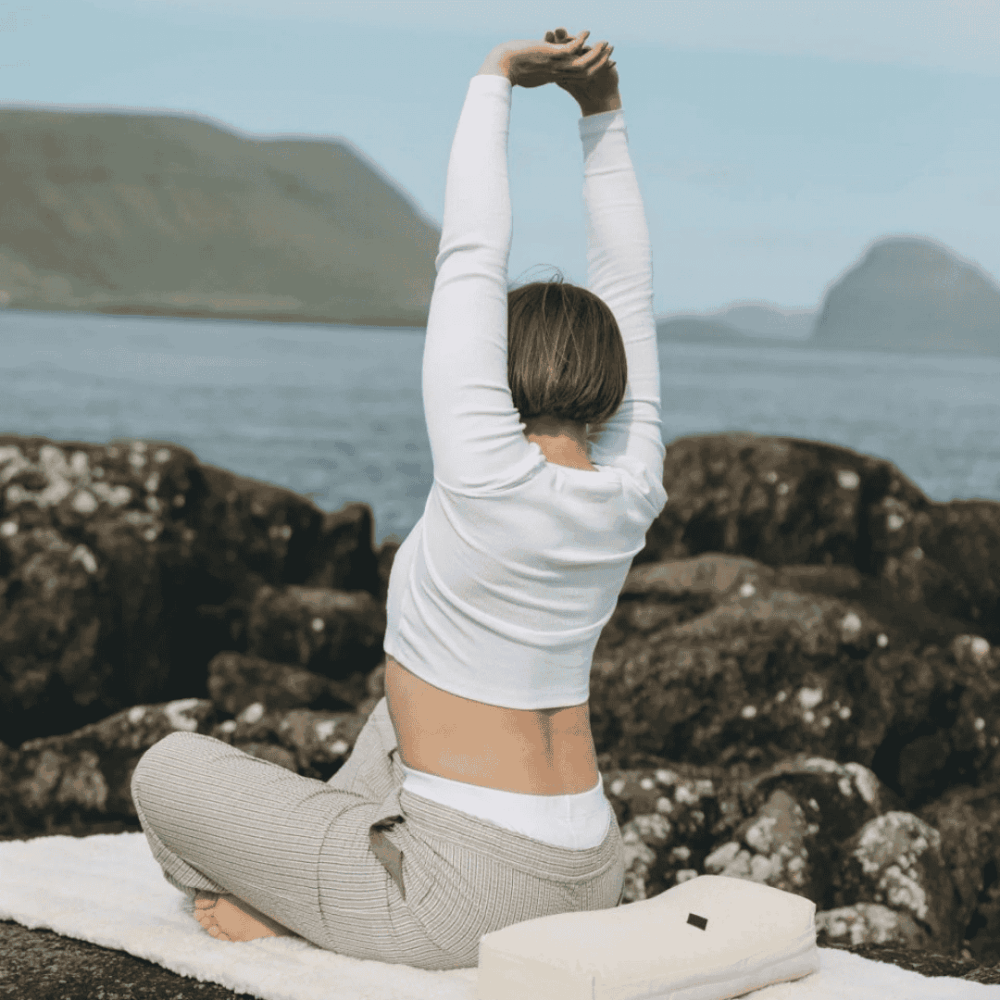 Kvinde der sidder på en Yin Yoga måtte